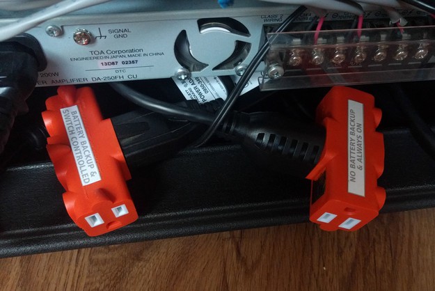 A close-up view of the two power splitters, one with battery backup and controlled by the power switch, the other without battery backup and always on