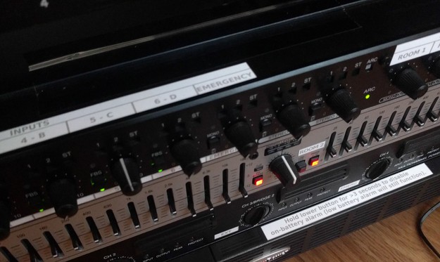An top-down angled view of the front side of the equipment in the rack, showing the custom labels on the mixer and power supply