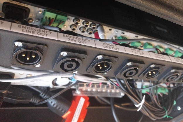 A top-down angled view of the patch panel on the rear of the rack, showing the custom label strip