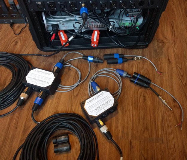 The rear of the rack case with cables, connectors, adapters, and transformer/splitter boxes for connections to two 8-ohm speakers